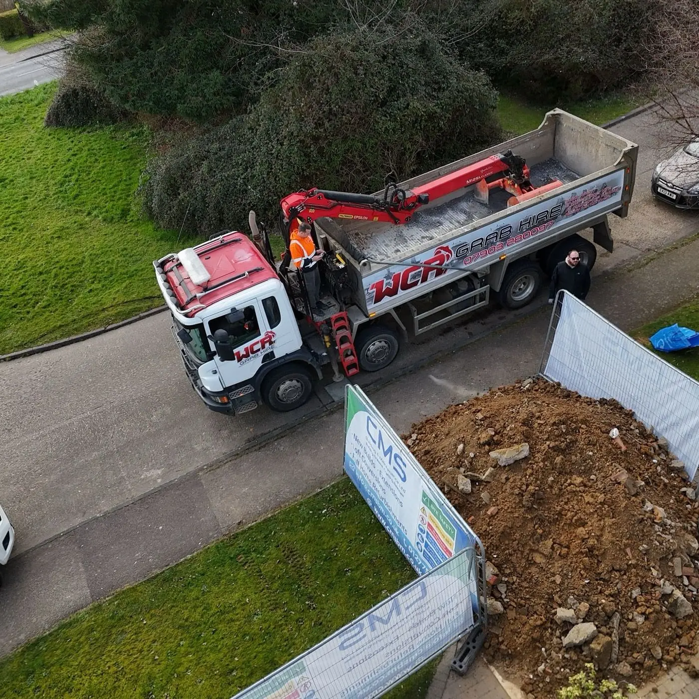 Overhead view of a WCR grab lorry beside excavated earth at a residential site